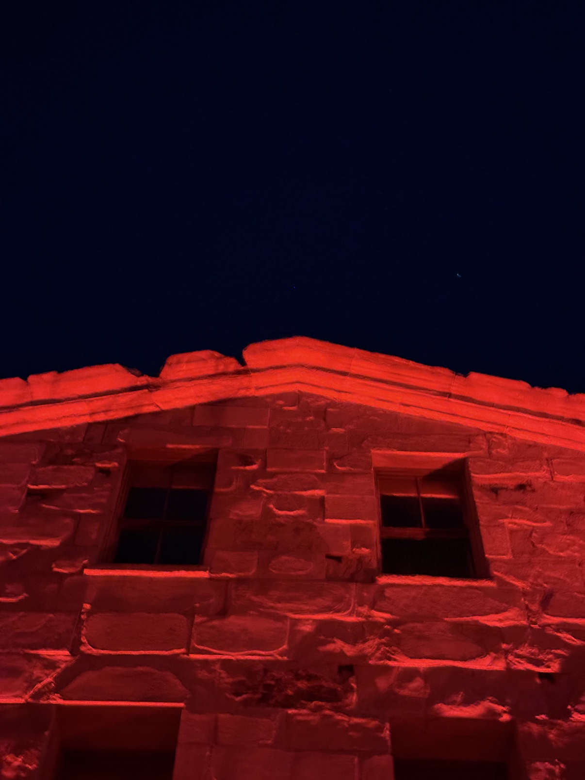 The SF Mint stone facade at night, washed in red PAR light