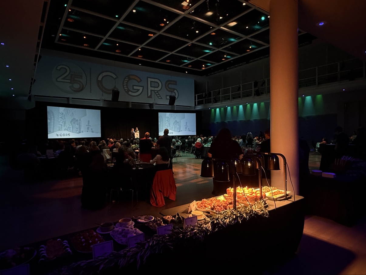The CGRS 25th Anniversary gala at Yerba Buena Center for the Arts — stage with a 25 CGRS banner, seated guests, and the buffet in the foreground